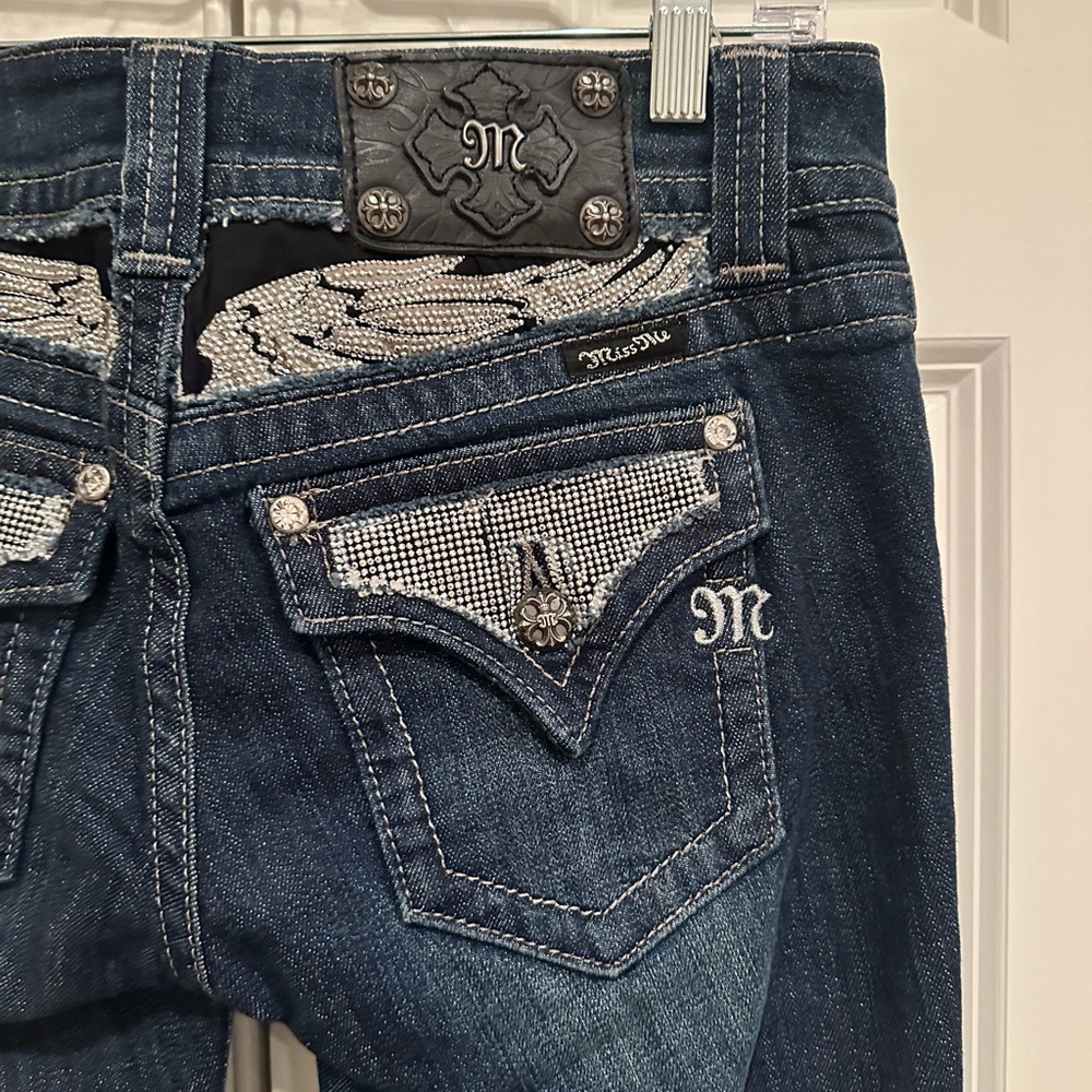 Stunning embellished “miss me” dark boot, cut jeans. Size 27.